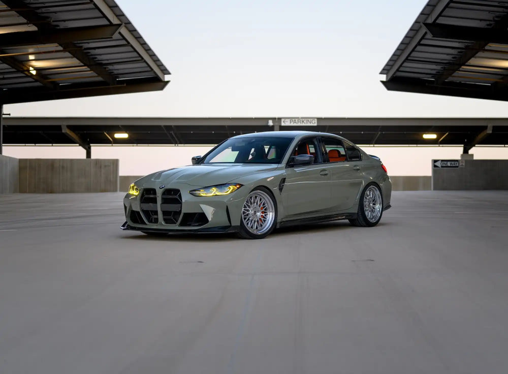 Light gray luxury sports sedan with custom multi-spoke wheels and a lowered suspension.