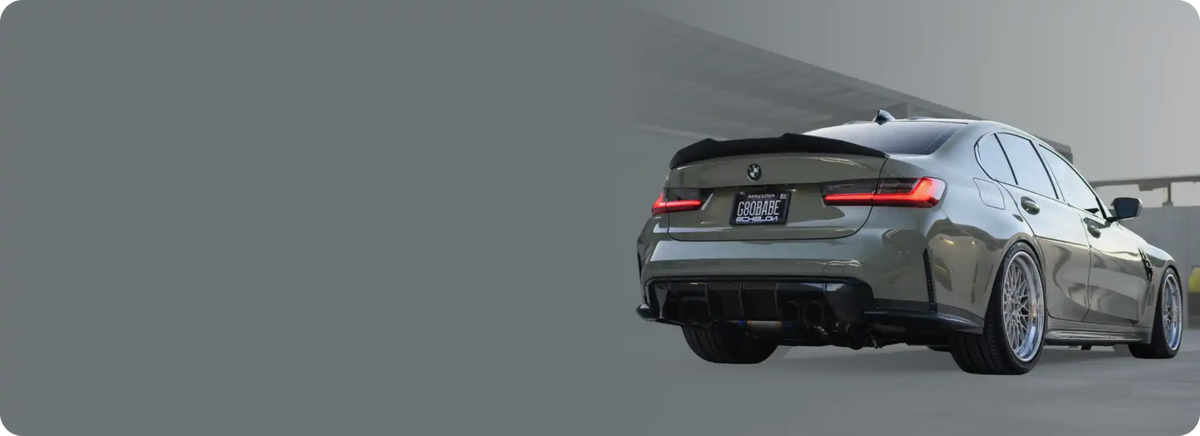 A sleek, customized gray sedan with a rear spoiler and aftermarket wheels.