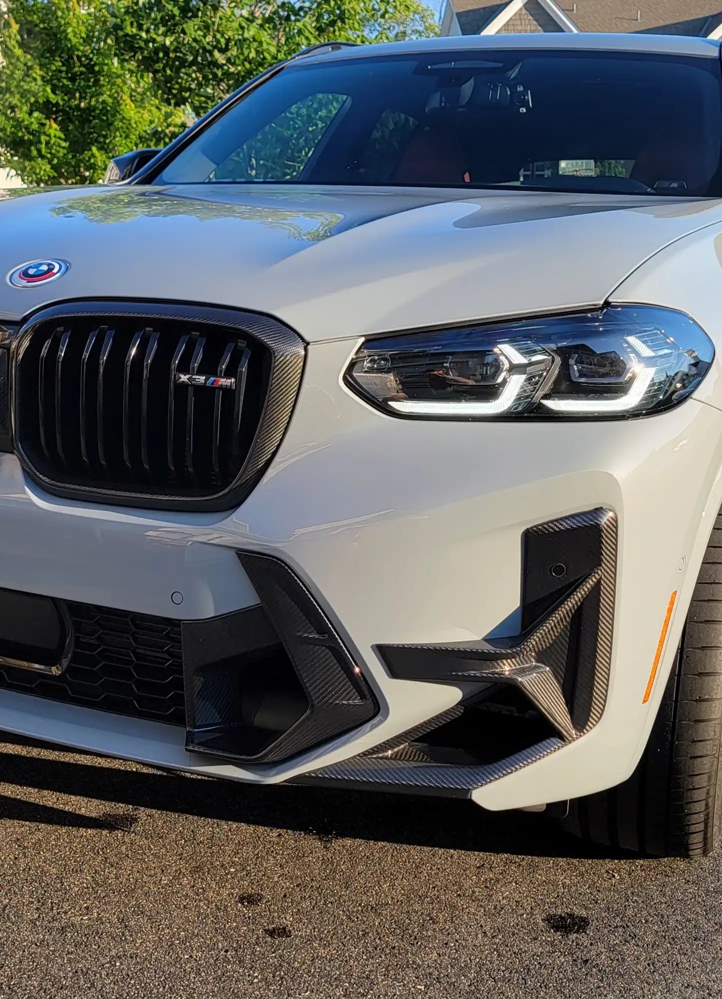 White BMW SUV with carbon fiber accents.